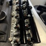 Close-up of two Plazmaman fuel rails on the intake runners, each feeding six injectors, one row nearer the cylinder head than the other